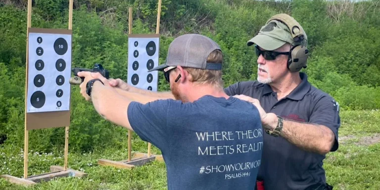 Close-up of shooter aiming handgun at targets